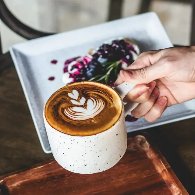 A latte with some light breakfast in the morning