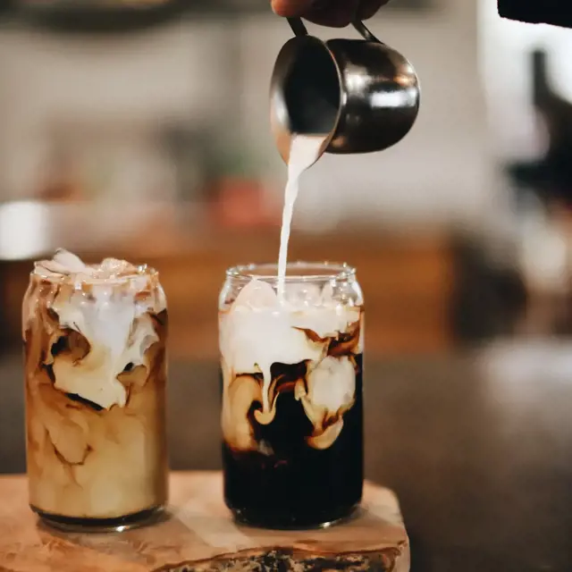 Pouring milk into a Classic Iced Coffee Latte